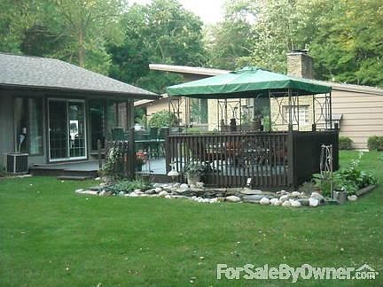 View of backyard facing the house / deck / pond.