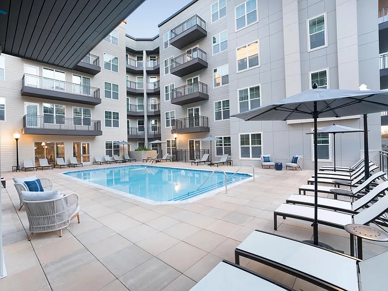 A resort-style pool anchors the courtyard at Modera Liberty Row, with lounge seating and balconies creating a relaxed, social setting in Charlotte.