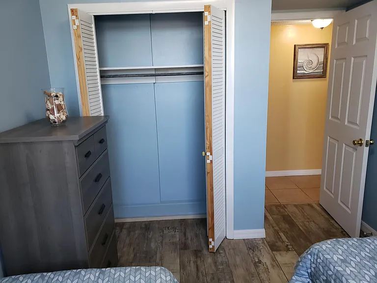 BR2 with 2 twin long beds, closet, dresser and nightstand.