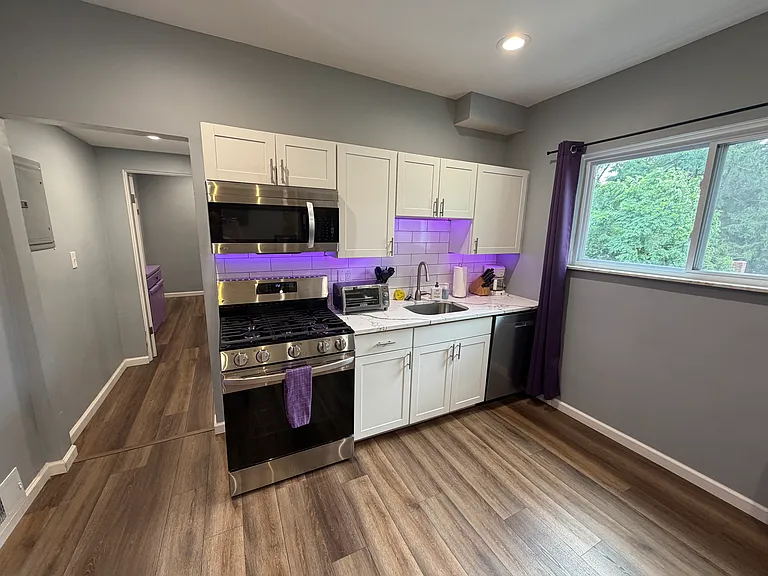Kitchen with new stainless steel appliances, full-size side-by-side fridge/freezer with icemaker and water on the door, and quartz countertops. Under cabinet lighting can be changed to any color or white.