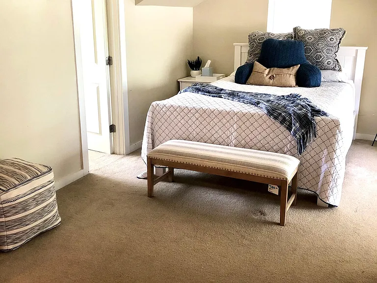 Walk-in closet with window to the left of the bed.