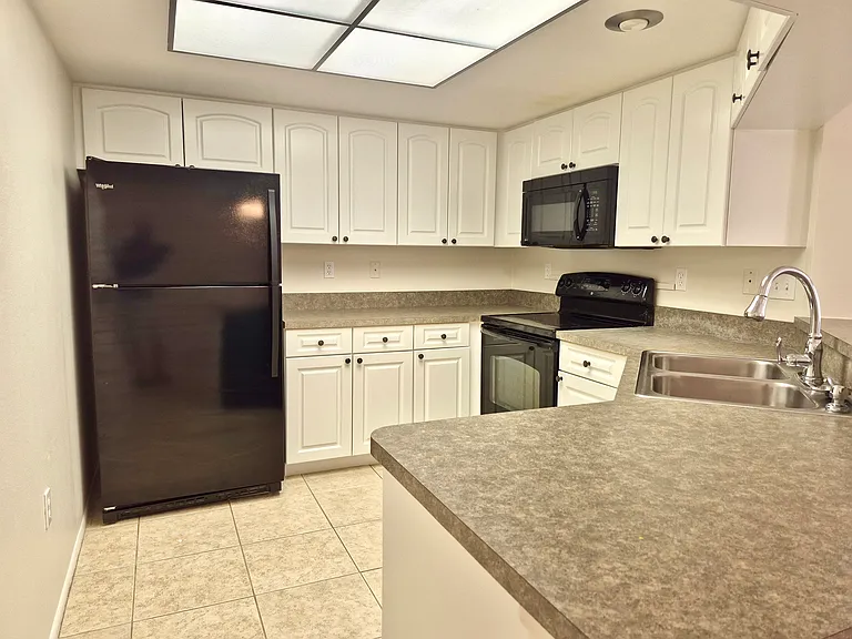 Kitchen with fridge and ample storage area.