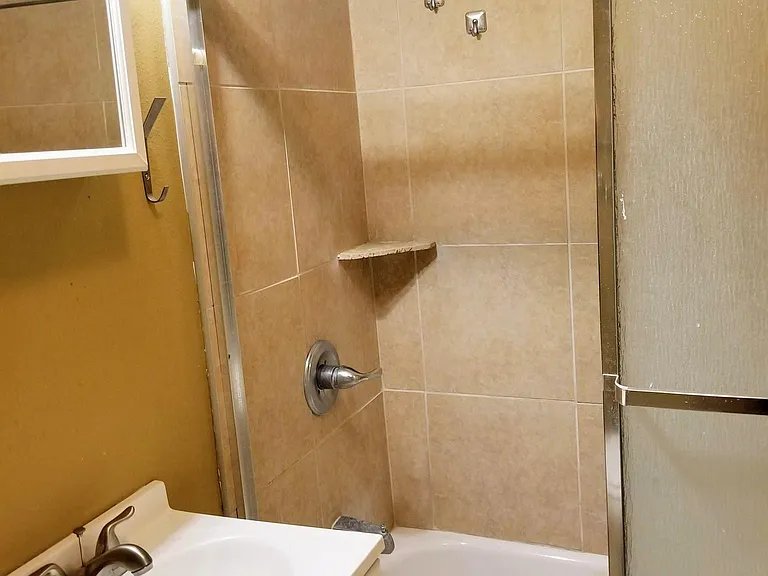 Bathroom with toilet, sink, and full shower with tub