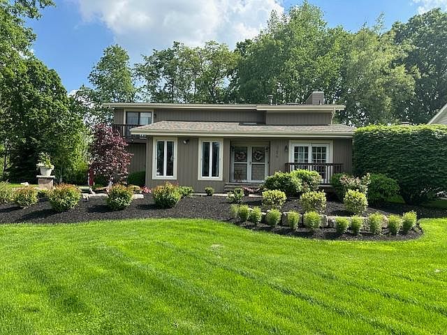 Front of Home: Showcases well-maintained landscaping with beautiful flowers and newly installed siding, creating an inviting and attractive curb appeal.