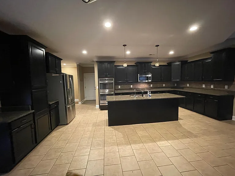 Spacious chef's kitchen with expansive cabinetry, granite countertops, and large island- perfect for cooking and entertaining.