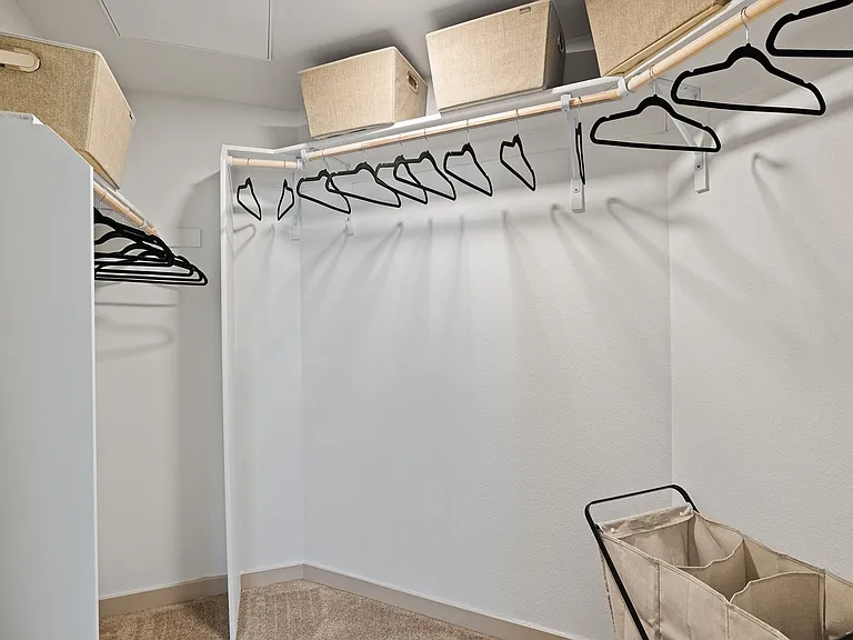 Keep everything organized in this roomy walk-in closet with built-in storage.