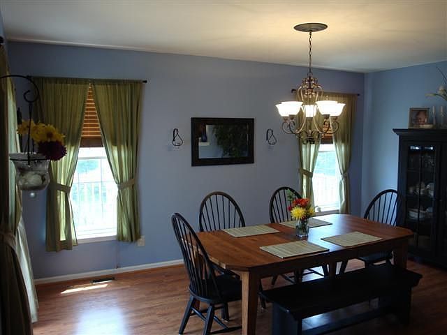 Highlights of the dining room include laminate flooring and a  chandelier