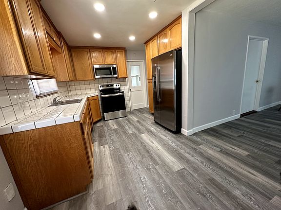 Kitchen with can lighting and new refridgerator, stove and microwave.
showing access to main living area.