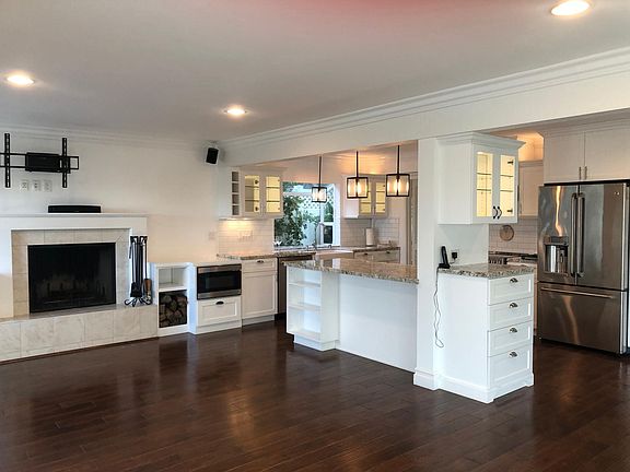 Family room with cozy fireplace open to remodeled kitchen