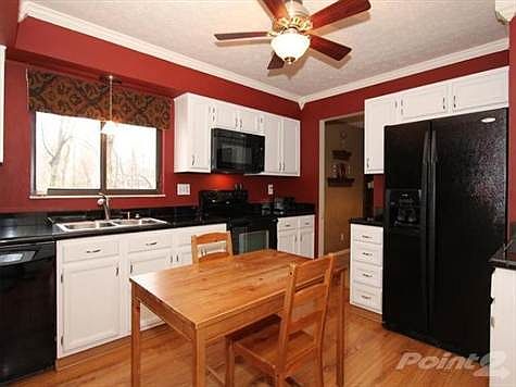 The updated kitchen offers granite tiled countertops, crown moldings, new ceiling fan & freshly painted cabinets with brushed nickel hardware.