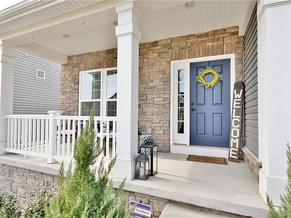 Charming, classic front porch with stone accent wall. A perfect spot to relax in the warmer months and good protection from the 