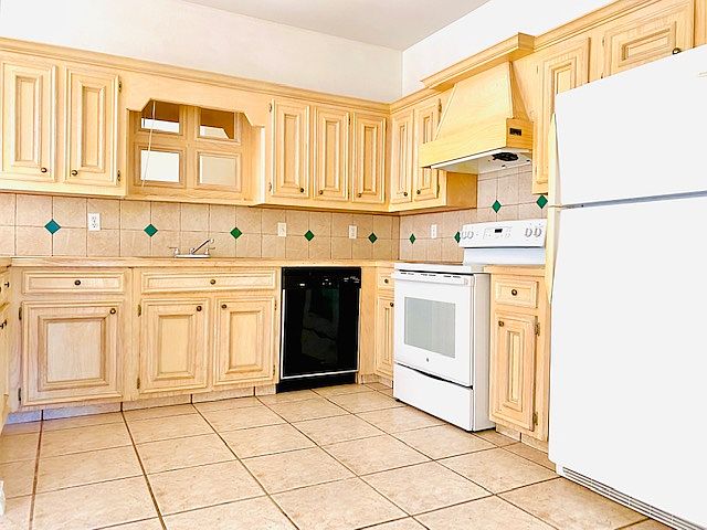 Kitchen equip with dishwasher, stove, refrigerator and custom cabinets.