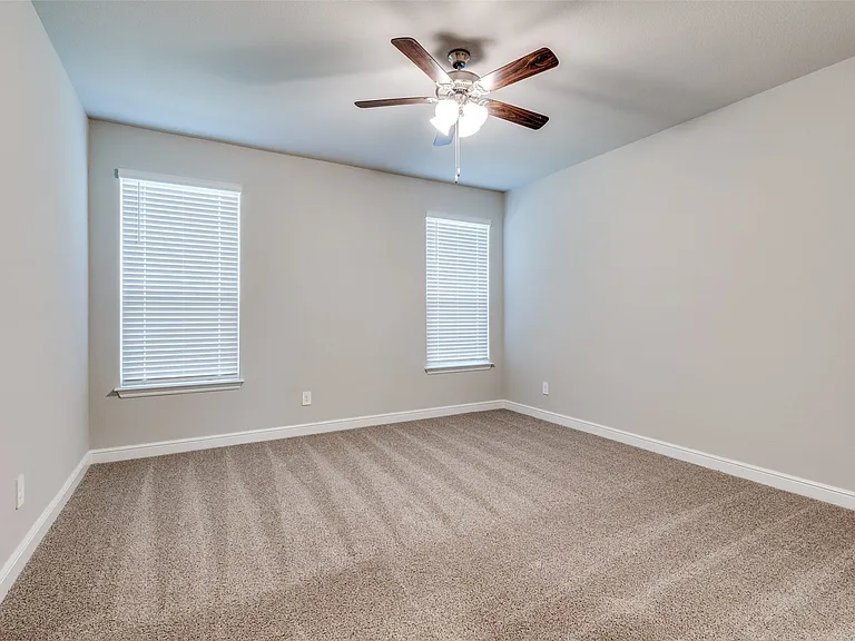 Unfurnished room featuring ceiling fan and carpet floors