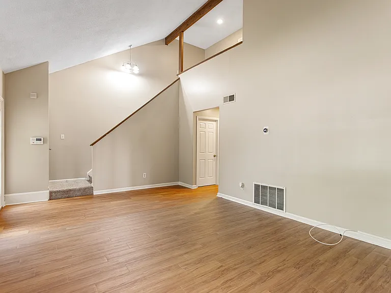 Valuted living room with hardwood floors.
