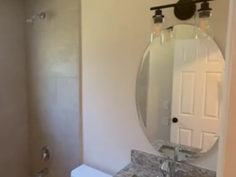 Brand new toilet, sink, tiled tub and granite counter matching kitchen counters.