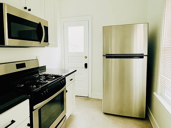 kitchen with door to back balcony. microwave included