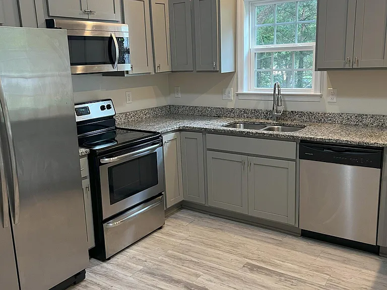 Kitchen featuring granite countertops and stainless steel appliances, designed for both convenience and entertaining.