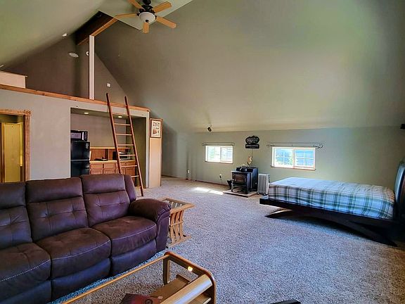 Living room and ladder to loft which holds a queen size bed and has a storage chest. There is also room for a dresser.