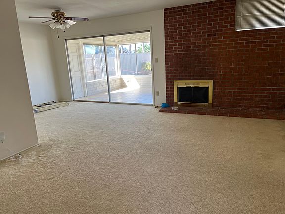 Living and dining area with view of the sunroom through the sliding glass doors