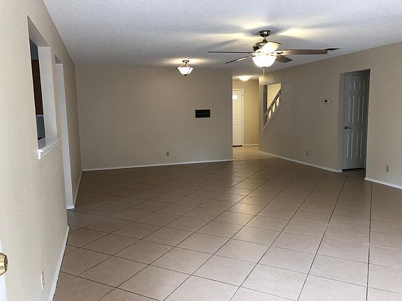 Family room from the back door. Front entrance and stairs in the background.