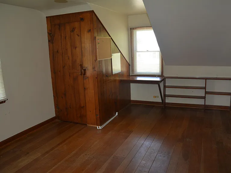 Upstairs bedroom over garage. Contains shelves and a built-in desk.