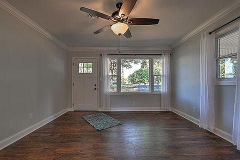 Sunny living room with hardwood flooring.