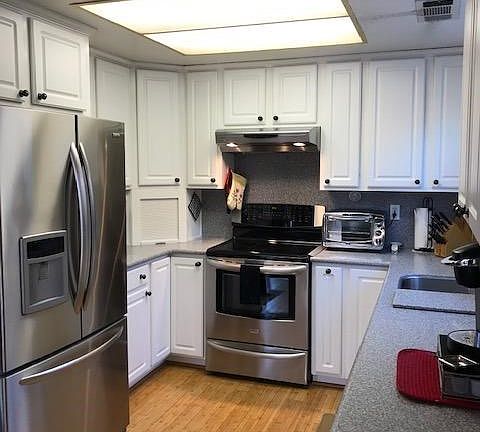 The kitchen has been updated with newer appliances and Corian countertops.