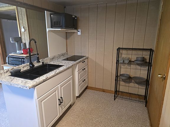 No garbage disposal in the sink. Otherwise, fully functional along with Dishes, Microwave, Toaster Oven (with air fryer), dishes, induction stovetop (and pans to cook with).