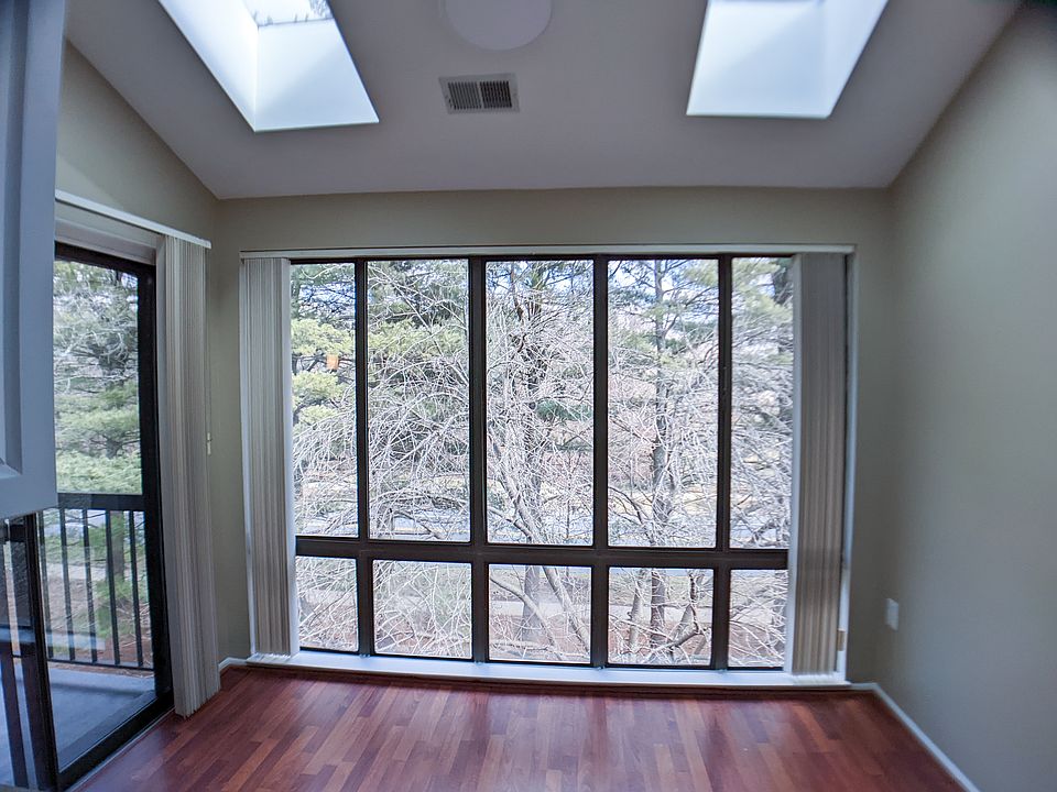 Sunroom / Breakfast nook with skylights and floor to ceiling window. ON the left is a second set of glass doors leading to the private patio.