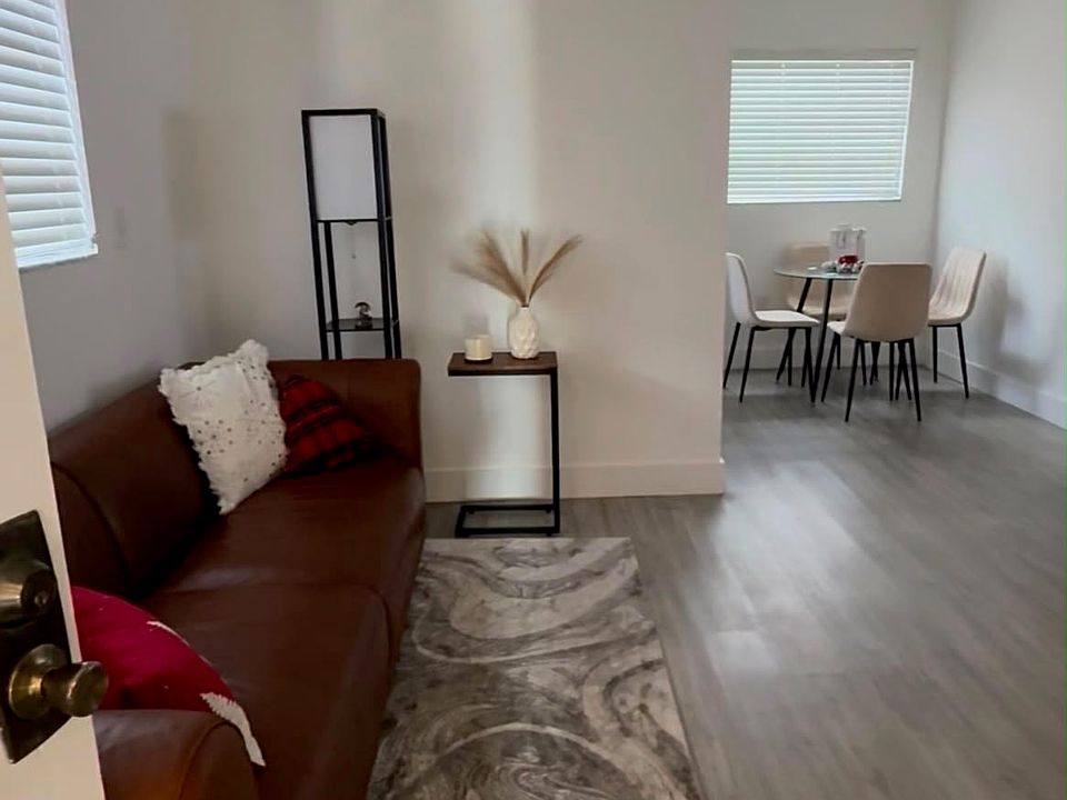 Bright and inviting living room featuring attractive wood-look flooring, neutral finishes, and ample space for comfortable seating and entertainment.