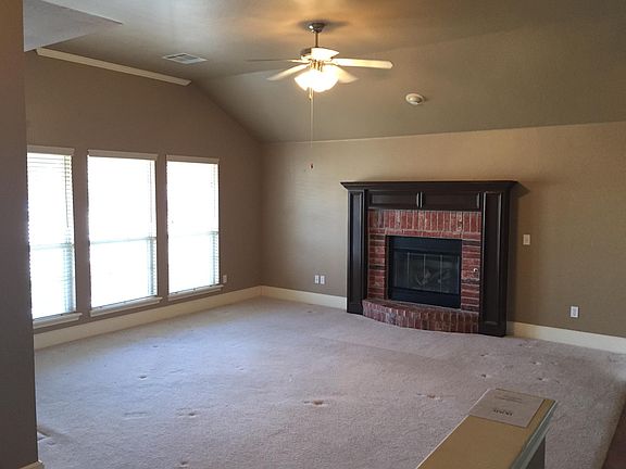 Living room with gas fire place, plantation shutters, and ne