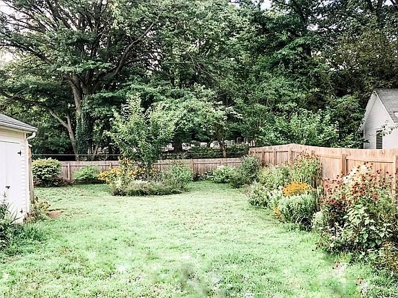 Gorgeous fenced-in backyard filled with flowers to bloom in all seasons.
