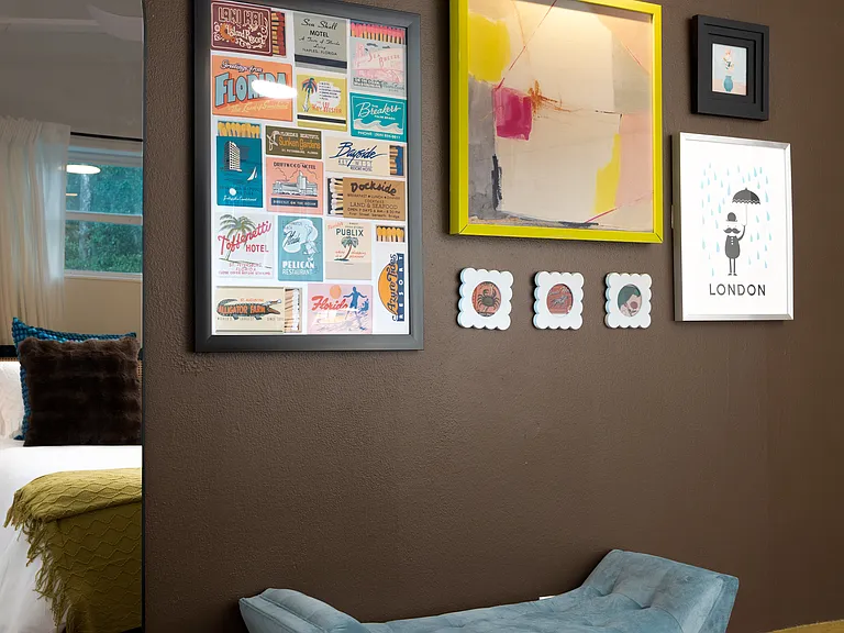 Bedroom two gallery wall, full length mirror and upholstered bench.
