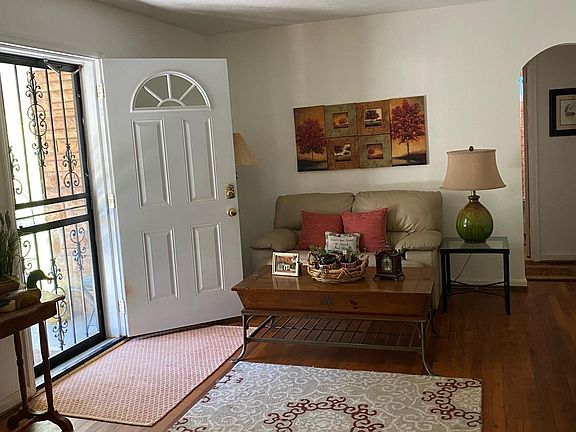 Living Room with arched doorway to 2 bedrooms and 1 full bathroom