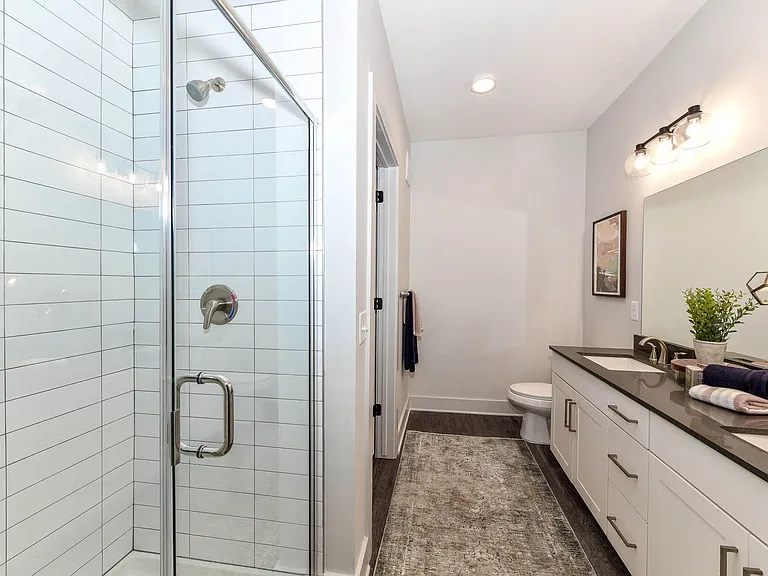 Select bathrooms include a glass-enclosed shower with custom tile surrounds.