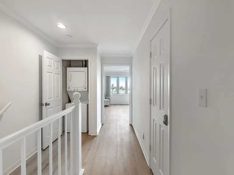 Upstairs hallway has a closet. Closet space holds the unit washer and dryer