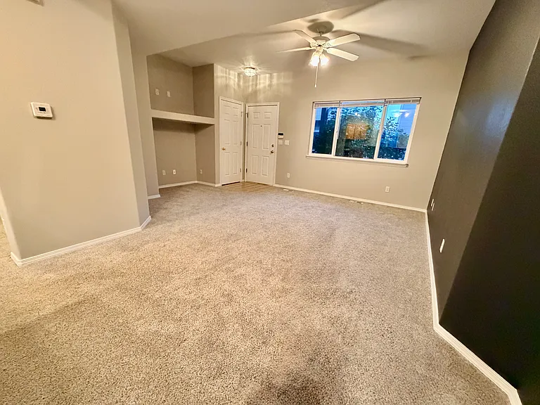 Another view of main level living room showing front door access.