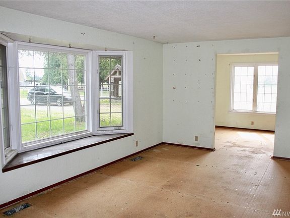 Large living room with bay window with dining room next to it, leading into the kitchen. The wall between the living room and the dining room is not a support wall, removing it would be easy. 