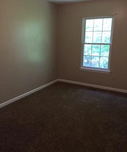 Bedroom at the back side of the house. It has a large closet and ceiling fan.