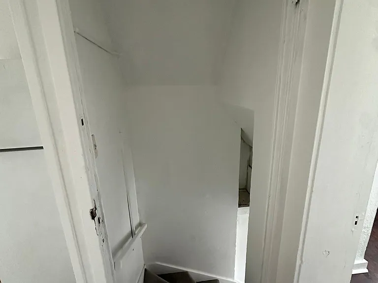 Kitchen, view of the secondary entry staircase door leading to the back yard, ally side. Tile floors and backsplash.