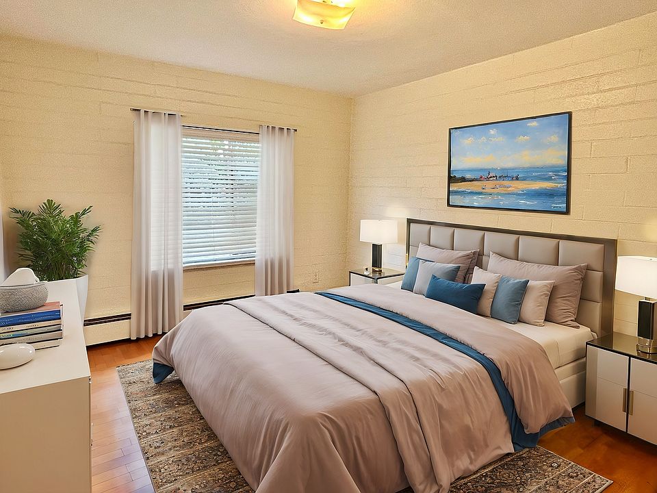 Inviting bedroom with elegant decor, featuring a cozy king-sized bed, modern artwork, and abundant natural light.