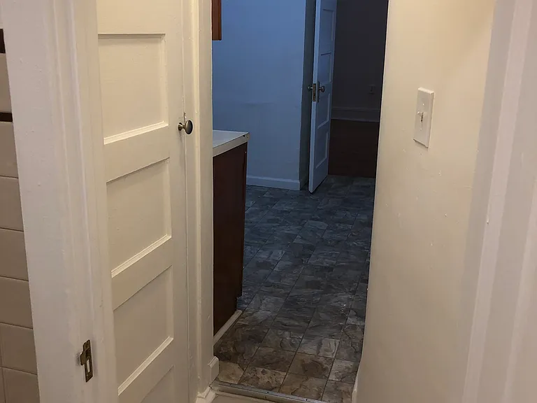 view from bathroom back to kitchen showing closet on left