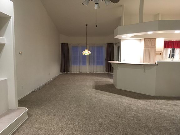 View of dining area and kitchen from living room space.