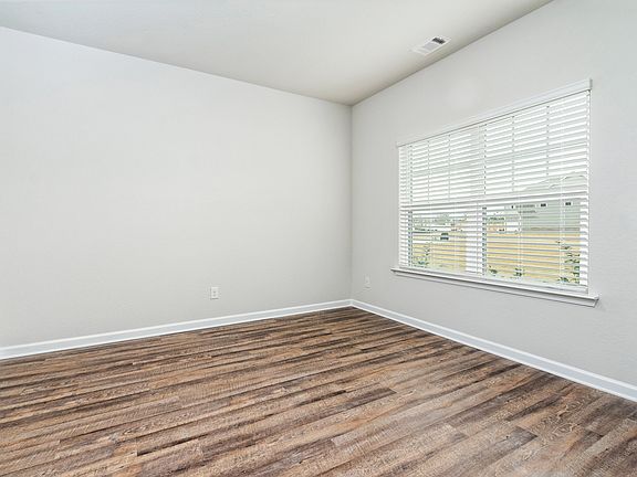 Formal dining room located off of the entry, with large windows and wood-style flooring.