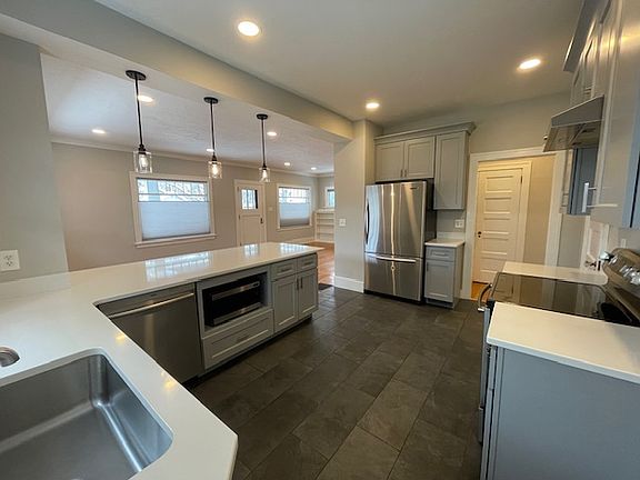 Spacious kitchen with white quartz countertops and breakfast bar