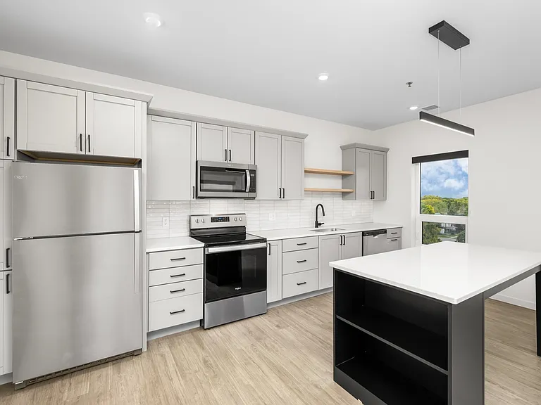 Modern kitchen with sleek gray cabinets, stainless steel appliances, and a spacious island under stylish lighting. Modern kitchen with sleek gray cabinets, stainless steel appliances, and a spacious island under stylish lighting.