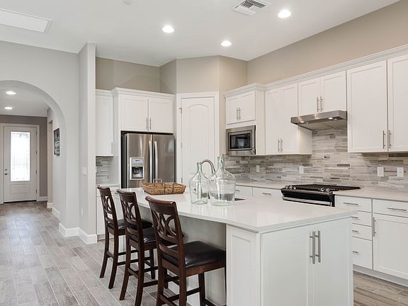 Model Representation Kitchen with stainless steel gas appliances, large center island, and 42 whit
