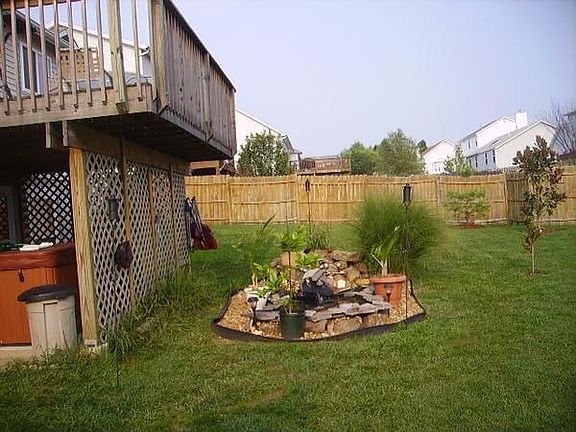 backyard with view of hot tub and pond