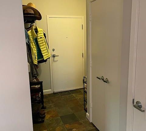 Entrance looking from edge of kitchen towards hallway (also, coat close at entrance)