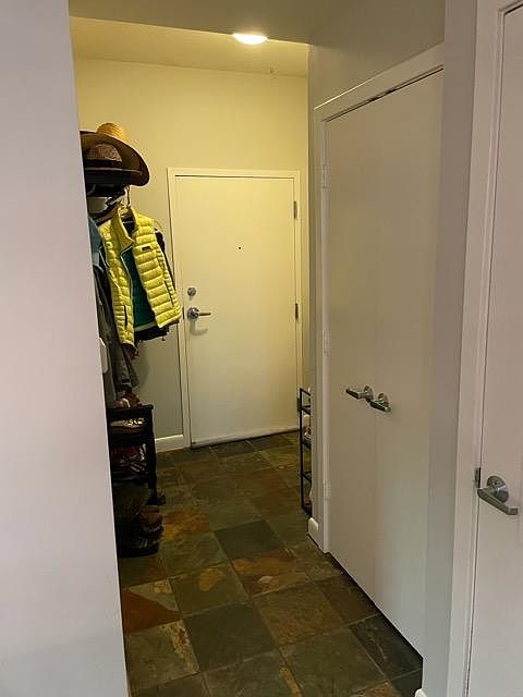 Entrance looking from edge of kitchen towards hallway (also, coat close at entrance)